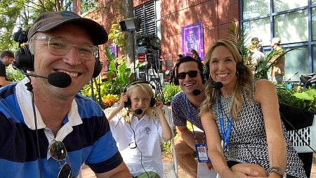 people in headsets seated outside at an event